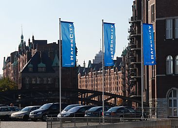 01_15795 - die blauen Flaggen der Hafencity wehen im Wind; im Hintergrund die Lagerhuser der Speicherstadt. 