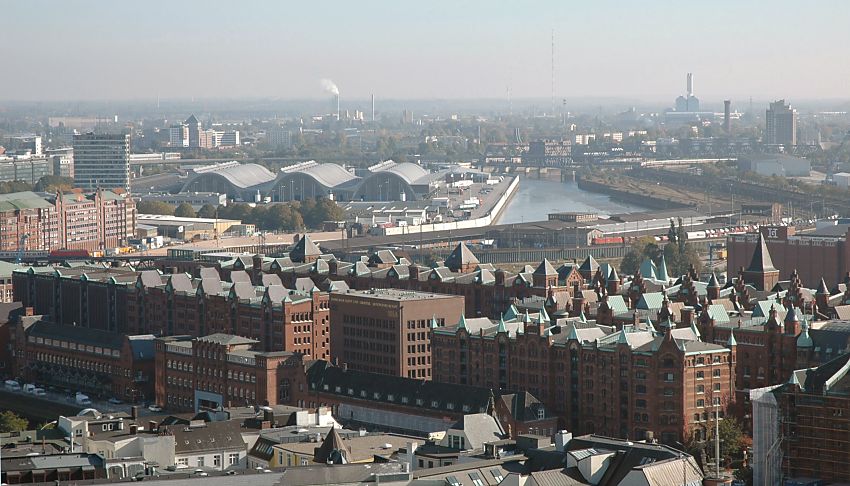 11_17550 Luftaufnahme von der Speicherstadt - im Vordergrund am Zollkanal die niedrigen Zollgebude, dahinter die Speicherblcke S, T und W. In der Bildmitte die moderne Architektur vom Hamburger Blumenmarkt /Gemsemarkt, rechts davon der Oberhafenkanal. Dahinter der Wasserturm vom Wasserwerk in Kaltehofe und das markante Gebude vom Kraftwerk Tiefstack. In der linken Bildmitte qualmt der Schornstein von der Mllverbrennungsanlage Borsigstrasse.