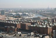 11_17550 Luftaufnahme von der Speicherstadt - im Vordergrund am Zollkanal die niedrigen Zollgebude, dahinter die Speicherblcke S, T und W. In der Bildmitte die moderne Architektur vom Hamburger Blumenmarkt /Gemsemarkt, rechts davon der Oberhafenkanal. Dahinter der Wasserturm vom Wasserwerk in Kaltehofe und das markante Gebude vom Kraftwerk Tiefstack. In der linken Bildmitte qualmt der Schornstein von der Mllverbrennungsanlage Borsigstrasse.