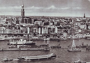 011_14565 - Blick ber die Elbe und den Vorsetzen auf Hamburg und die St. Michaeliskirche; rechts der Rundbunker an den Vorsetzen - im Vordergrund wird eine Schute von einem Schlepper gezogen, am Ponton liegt ein kleiner Schwimmkran (ca. 1955).