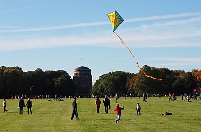 011_15805 - Kinder lassen auf der grossen Wiese im Stadtpark einen Drachen steigen; er hat eine Sonne aufgemalt und einen langen bunten Schwanz; im Hintergrund das Planetarium.