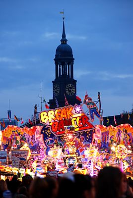 011_15223 - farbige Lichter auf dem Hamburger Dom; im Hintergrund das Wahrzeichen der Hansestadt: die St. Michaeliskirche, kurz "Michel" genannt.