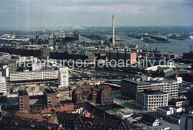 011_15741 - Luftbild vom Hamburger Hafen ca. 1970; im Vordergrund Teile der Hamburer Innenstadt, dahinter die Klinker - Architektur der Lagergebude der Speicherstadt und am Grasbrookhafen der hohe Schornstein des HEW Kraftwerk Hafen, links die Anlage der Hamburger Gaswerke.