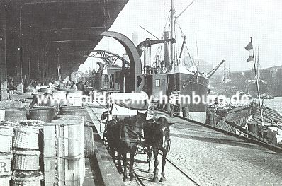 011_15756 - Frachtgut, wie z.B. Krbe, Fsser und Kisten, die von den Schiffen entladen wurden, lagern auf dem Dalmannkai; Pferd und Wagen warten auf ihre Kutscher und die Fracht. Im Hintergrund schemenhaft die Gaswerke und rechts der Hbenerkai.