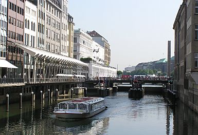 011_15618 - Blick zur Alsterschleuse; lks im Hintergrund die Bgen und Sulen der Alsterarkaden; vorne lks. bei der  berdachung zeigt den Alsterwanderweg Richtung Elbe.