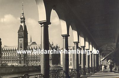 011_15651 - Blick durch die Sulen -  Rundbgen der Alsterarkaden zum Hamburger Rathaus; einige Passanten bummeln durch die Einkaufspassage. (Fotografie ca. 1935)