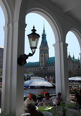 011_15653 - Sonnenschirme schtzen die Gste und spenden Schatten; am Pfeiler der Arkade eine historische Laterne.