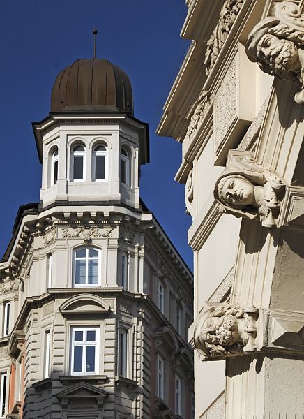 11_18982 Erkerturm mit kleiner Kuppel auf einem historischen Gebude in den Hamburger Colonnaden. An den Bgen der Arkaden zeigen Stuckdekore mnnliche und weibliche Kpfe.  Blauer Himmel ber Hamburg www.bildarchiv-hamburg.de