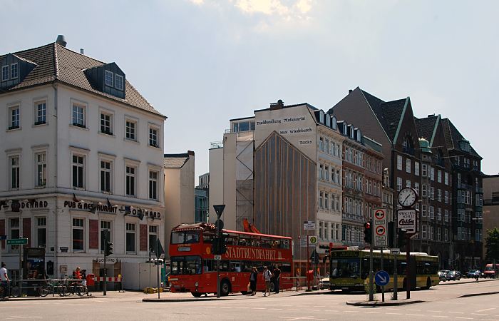 11_19001 In der historischen Bebauung der Dammtorstrasse wurde einige Gebude abgerissen; in der Baulcke ist die Kontur eines Hauses an der Hauswand zu erkennen. Ein roter Doppeldeckerbus der Hamburger Stadtrundfahrt steht an der Ampel - ein Gelenkbus der Hamburger Hochbahn AG /HHA steht an der Bushaltestelle, die Fahrgste sind eingestiegen. www.bildarchiv-hamburg.de