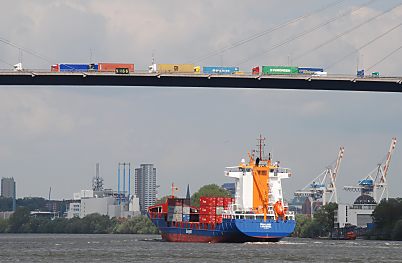 011_15627 - auf der Khlbrandbrcke transportieren Lastwagen Container; darunter fhrt ein beladener Frachter.  