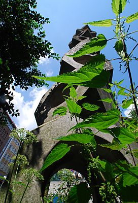 011_15728 - Skulptur / Stele an der Strassenunterfhrung - Brennnesseln wachsen am Fuss des Kunstwerks.