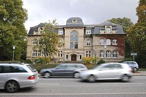 Gebude der Friedhofsverwaltung an der Fuhlsbttler Strasse - Stadtteil Hamburg Ohlsdorf. Bilder aus Hamburg OHLSDORF, Bezirk Hamburg NORD. Ohlsdorf kam 1325 in den Besitz des Zisterzienserinnenklosters Harvesterhude und spter zum Kloster St.Johannes. Ohlsdorf wurde 1830 in das Hamburger Landgebiet aufgenommen, 1913 zum Vorort. Ein groer Teil des wenig fruchtbaren Gebietes wurde 1874 von Hamburg fr seinen neuen Stadtfriedhof gekauft. Der Ohlsdorfer Friedhof ist mit 391 ha einer der grten Parkfriedhfe der Welt. Bislang wurden hier knapp 1,7 Millionen Menschen beigesetzt und ber das gesamte Areal verteilen sich 280.000 Grabstellen. Im Stadtteil Hamburg OHLSDORF leben auf einer Flche von 7,2 km ca. 14 000 Einwohner. 