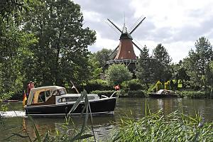 Reitbrooker Mhle am Ufer der Dove-Elbe - Windmhle mit Flgeln in Hamburg - Schilf am Flussufer - Motoboot in Fahrt. Bilder aus den Stadtteilen und Bezirken der Hansestadt Hamburg - Fotos von Hamburg REITBROOK, Bezirk Hamburg BERGEDORF. Seit 1768 gehrt Reitbrook zu Hamburg - jetzt leben auf 6,9 km ca. 500 Einwohner.