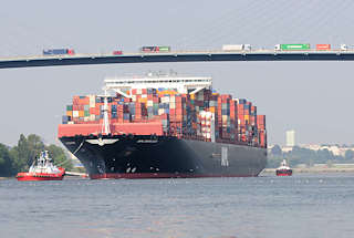 0430 Der Containerfrachter APL MERLION auf der Sderelbe in Fahrt zum Hamburger Container Terminal Altenwerder - der 368m lange Megaboxer kann 14 000 TEU Container an Bord nehmen. Schlepper dirigieren den Conterainerriesen im Fahrwasser. LKW mit Containern fahren auf der Khlbrandbrcke, die den Khlbrand vom Hamburger Stadtteil Wilhelmsburg nach Waltershof berspannt. 