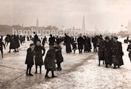 1086_3505_51 Kinder mit ihren Müttern auf dem Eis der zugefrorenen Aussenalster - einige haben Schlittschuhe untergeschnallt, andere glitschen auf dem Eis. Im Hintergrund Kirchtürme der Hansestadt Hamburg. 