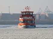 11_22732 Die Hafenfhre TOLLERORT  der Hamburger Fhrschiffreederei HADAG kommt von Hamburg Finkenwerder und legt am Anleger "Dockland" in Hamburg Neumhlen an. Dicht treibt das Eis auf der Elbe, noch knnen sich die Schiffe ihren Weg durch die Eisschollen bahnen. Im Hintergrund sind auf der anderen Elbseite die Container auf dem Gelnde des Terminals Tollerort gestapelt. www.fotograf-hamburg.de