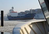 11_22733 Der niederlndische Containerfeeder Klostertal fhrt durch den Eisgang auf der Elbe flussabwrts - das Schiff spiegelt sich in der Scheibe einer Hafenfhre. Hinter dem Frachtschiff luft ein hoch beladener Containerfrachter in den Hamburger Hafen ein.  www.fotograf-hamburg.de