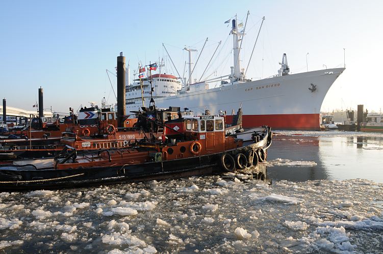 SAMMELSURIUM || Bild aus dem winterlichen Hamburg - Schlepper + Eisgang auf der Elbe  11_22740 Schlepper liegten bei den Landungsbrcken an den Dalben. Eisschollen treiben auf dem Wasser der Elbe. Im Hintergrund das Museumsschiff CAP SAN DIEGO. www.fotograf-hamburg.de