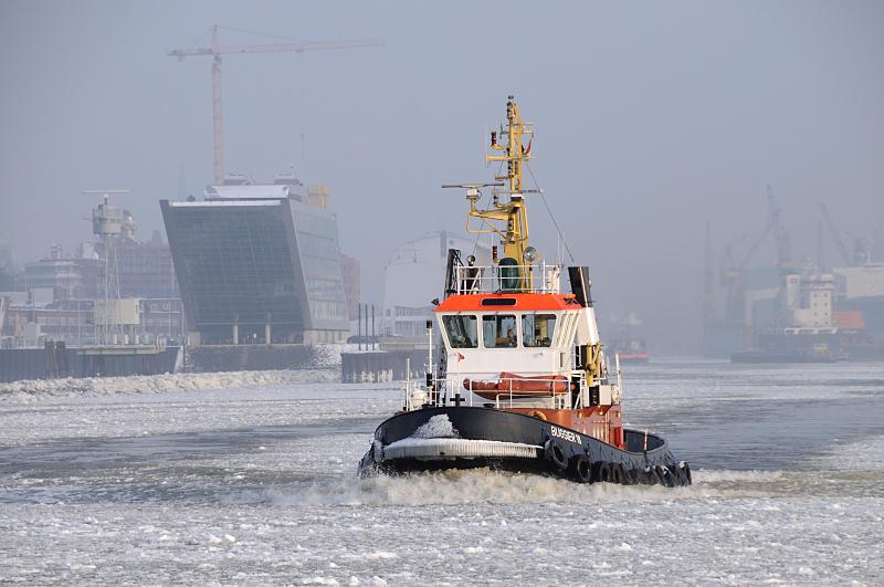 Winter in Hamburg - Schlepper im Eis auf der Elbe im Hamburger Hafen. 197_5410 Der Schlepper BUGSIER 18 fhrt durch das Eis auf der Elbe zu seinem Liegeplatz am Ponton in Hamburg Neumhlen. Links die futuristische Architektur des Brogebude Dockland - rechts die Werftanlagen von Blohm + Voss. www.fotograf-hamburg.de