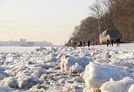 207_5797 Die Eisschollen am Elbufer glnzen in der Wintersonne - Spaziergnger genieen das sonnige Hamburgwetter an der Elbe. Am Strand liegt der Findling ALTER SCHWEDE, der 1999 bei Baggerarbeiten in der Elbe gefunden wurde. Der Stein hat ein geschtztes Alter von 1,8 Milliarden Jahren und ein Gewicht von 217 t; er wurde vor ca. 400 000 Jahren whrend der Elster-Eiszeit aus dem Raum Schweden mit den Gletschern hierher gebracht.  