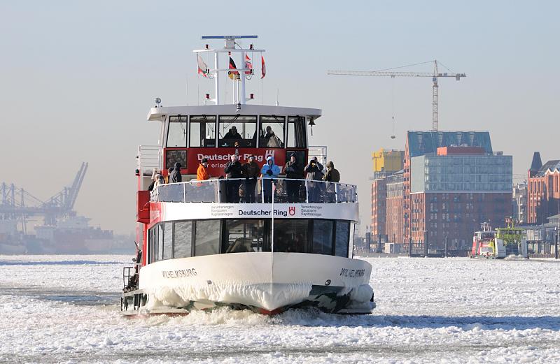Fotos vom Winter in der Hansestadt Hamburg - Elbfähre im Eis. 210_5639 Die Elbfähre WILHELMSBURG kommt von Hamburg Finkenwerder und fährt durch das dichte Treibeis Richtung Landungsbrücken. Der Bug des Fahrgastschiffs ist vereist - auf dem Vorderdeck stehen Touristen und fotografieren die vereiste Elbe. Im Hintergrund der Anleger Altona Fischmarkt und die ehem. Speichergebäude an der Großen Elbstraße.