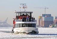 210_5639 Die Elbfhre WILHELMSBURG kommt von Hamburg Finkenwerder und fhrt durch das dichte Treibeis Richtung Landungsbrcken. Der Bug des Fahrgastschiffs ist vereist - auf dem Vorderdeck stehen Touristen und fotografieren die vereiste Elbe. Im Hintergrund der Anleger Altona Fischmarkt und die ehem. Speichergebude an der Groen Elbstrae. 