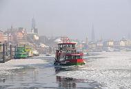 211_5327 Die Elbfhre REEPERBAHN bahnt sich ihren Weg durch das dichte Treibeis auf der Elbe - im Hintergrund das typische Hamburg Panorama mit den unterschiedlichen Kirchtrmen im Dunst des Winternachmittags.