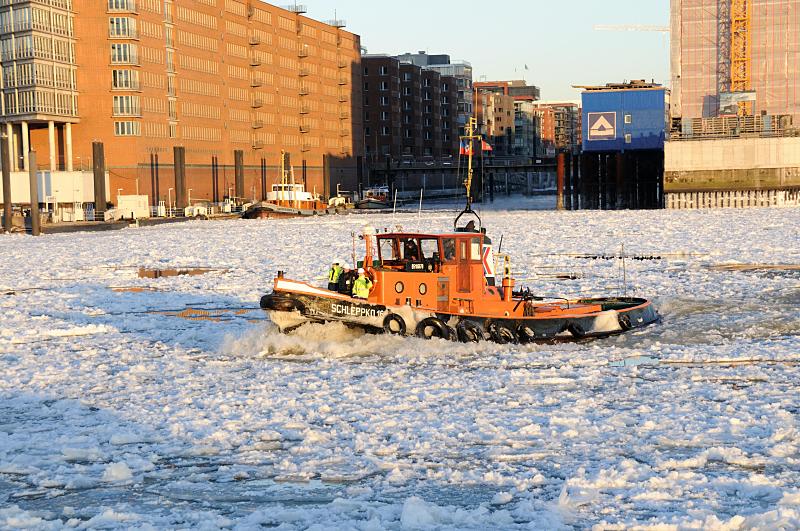 Schlepper im Treibeis vor der Einfahrt zum Sandtorhafen. 220_5863 Der Schlepper SCHLEPPKO 16 fhrt im dichten Treibeis auf der Elbe vor der Einfahrt des Sandtorhafens. Damit das Treibeis, das die Elbe bedeckt, sich bei abflieendem Wasser nicht aufstaut, wird es von den Schleppern und Hamburger Eisbrechern in Bewegung gehalten.