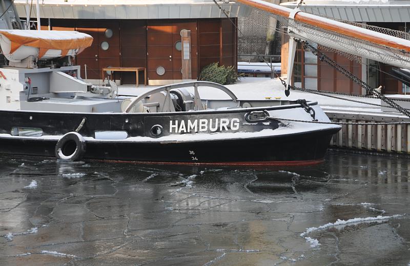 Hamburger Traditionsschiffhafen im Eis - Schlepper Fairplay VIII. 222_4879 Das Wasser im Hamburger Traditionsschiffhafen ist mit Eis bedeckt - am Ponton des Sandtorhafens liegt der historische Schlepper FAIRPLAY VIII, das Heck des Arbeitschiffs ist mit Schnee bedeckt; an der Seite steht der Heimathafen Hamburg.