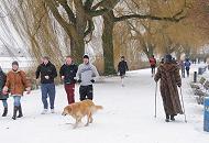 232_5101 Es gehört mit zur hanseatischen Tradition am Sonntag Nachmittag einen Alsterspaziergang zu unternehmen. Eine Dame im Pelzmantel und Nordic Walking Stöcke geht ihren Weg durch den Schnee am Alsterufer. Andere joggen mit kurzer Hose durch das Schneetreiben.