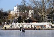 236_5518 Eine Mutter geht auf der zugefrorenen Alster vor dem Anleger RABENSTRASSE spazieren - sie schiebt ihren Kinderwagen ber das Eis wo im Sommer die Alsterschiffe fahren. 