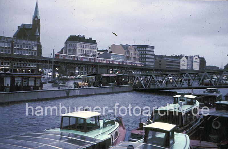 Hamburger Hochwasser 1976 - Sturmflutschutzanlage JOHNANNISBOLLWERK. 09_61 Die Sturmflut hat bei den Hamburger St. Pauli Landungsbrcken 1976 einen Hhe von 6,45 ber Normalnull erreicht. Das Wasser der Elbe steht bis kurz unter der Krone der Sturmflutschutzanlage am Johannisbollwerk. auf der Promenade und der Wassertreppe die zu den Anlegern hinunterfhrt, stehen Schaulustige in Regenjacken und beobachten den Wasserstand. 