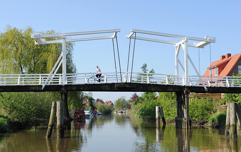 Bilder vom Alten Land - auf der Lühe, Hohendiekbrück / Steinkirchen. Historische Holzbrücke über den Fluß; Holzdalben zum Schutz der Anlage. 018_4033 Die historische Zugbrücke über die Lühe bei Steinkirchen kann hochgeklappt werden so dass Schiffe mit hohen Masten problemlos passieren konnen. Früher haben die Obstbauer ihre reiche Ernte mit einem Lastsegler auf den Obstmarkt transportiert.