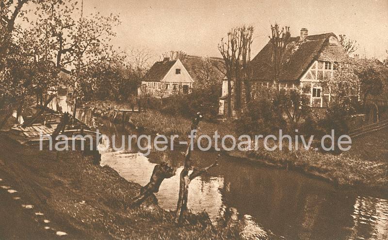 Historische Aufnahme von der Lühe - Bauernhäuser im Alten Land. Fachwerkhäuser am Ufer der Lühe - Lastsegler am Anleger. 018_1_3504 Die Obstbauer haben ihre Ernte mit einem Lastsegler auf den Obstmarkt transportiert; der Mast konnte nieder gelegt werden, so dass auch niedrige Brücken durchfahren werden konnten. Ein Ewer liegt am Anleger an der Lühe - auf der anderen Seite des Flusses reetgedeckte Fachwerkhäuser.