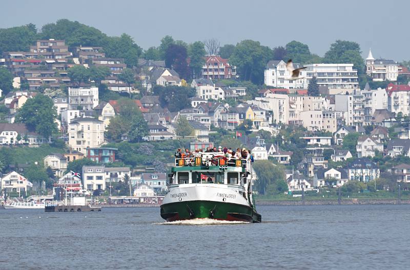 Bilder vom Hamburger Elbufer - Metropolregion Hamburg. Fähre FINKENWERDER auf dem Weg zum Anleger Cranz. 027_4171 Die Elbfährte verkehrt zwischen dem Anleger Blankenese und Cranz am Estesperrwerk. Diese Fährverbindung über die Elbe, gilt als eine der ältesten Hamburg - im Mittelalter wurden jede Woche dort Hunderte von Ochsen mit Booten über die Elbe gebracht. Die Fahrgäste auf der Elbfähre geniessen den Fahrtwind und die Sonne auf dem oberen freien Deck des Fährschiffs - im Hintergrund der Anleger und Wohnhäuser Blankeneses.