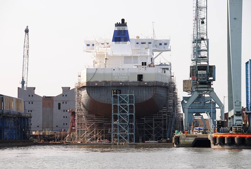 Fotos aus Hamburg - Schiffsbau auf der Sietas-Werft, Neuenfelde (2009). Bau eines Container-Feeders, Schiffsrohbau auf der Schiffswerft Sietas KG. 031_7448 Direkt hinter dem Sperrwerk liegt an der Este die Schiffswerft Sietas KG. An einem der letzten Containerschiffsneubauten der Traditionswerft wird gerade gearbeitet - Gerüste sind um den Rumpf des Schiffs aufgestellt. Ab Ende 2009 wurde konzentrierte sich die Werft auf den Neubau von Schwerlastschiffen und Fähren.