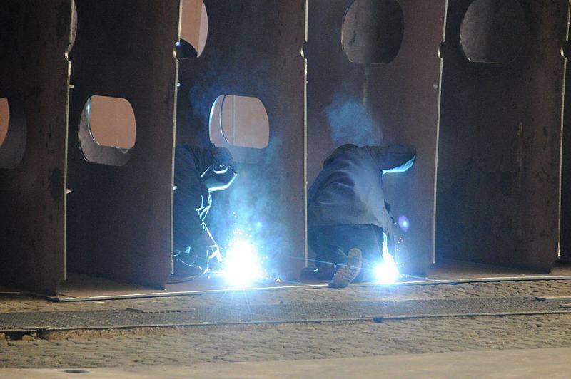 Hamburger Bilder - Werftarbeiter bei auf der Schiffwerft Sietas KG, Hamburg Neuenfelde. Schweisser bei der Arbeit am Schiffsrumpf eines Schiffsneubaus. 033_5109 Zwei Werftarbeiter der J. J. Sietas KG Werft beim Neubau eines Container-Feeders; die ARbeiter schweißen einzelne Rumpfsegmente zusammen. Die Hamburger Traditionswerft wurde 1635 gegründet und bis 2009 befand sich sie sich 9 Generationen lang im Familienbesitz.