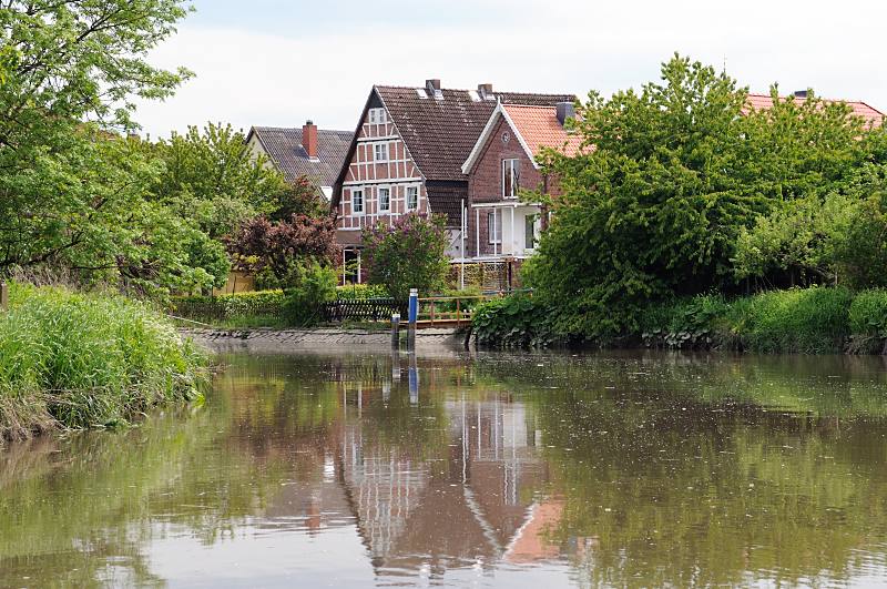 Bilder aus dem Alten Land - Fluss im Alten Land, Wasserweg Este. Wohnhäuser am Fluss- Ufer; Bootsanleger. 053_7429 Die Wohnhäuser liegen direkt am Ufer der Este - fast jedes der Einzelhäuser hat einen eigenen Bootsanleger für ein Sportboot. Ein Gütertransport auf dem Altländer Wasserweg, wie er früher z.B. mit Ewern vorgenommen wurde, finde nicht mehr statt - die Este ist ein Sportbootrevier geworden.