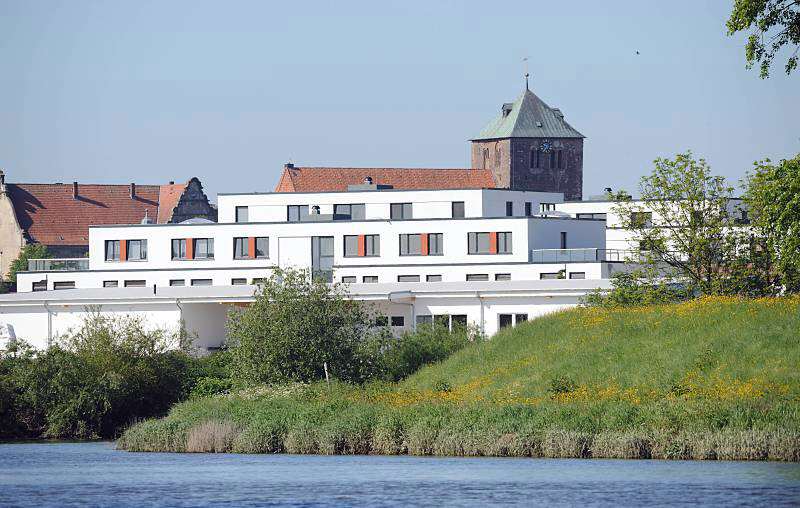 Moderne Neubauten - historische gotische St. Wilhadi Kirche, Stade. Aufnahmen der Sehenswürdigkeiten aus der Hamburger Metropolregion. 074_4793 Blick über die Schwinge nach Stadt. Am Ufer des niedersächsischen Flusse weisse Neubauten, dahinter die historische St. Wilhadi Kirche. Die gotische Kirche wurde nach dem Bischof Willehard benannt, der als Missionar in Friesland und Sachsen aktiv war und heilig gesprochen wurde.