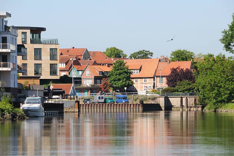 Sehenswürdigkeiten + Tourismusattraktionen der Metropolregion Hamburg / Hansestadt Stade. Hafeneinfahrt Stade - Neubauten, historische Architektur. 077_8066 Einbiegung der Schwinge in den Stader Hafen - 2009 wurden am Stader Hafenrand Bürohäuser und Wohnungen direkt am Wasser fertig gestellt. Einige der exklusiven Wohnhäuser haben einen eigenen Schiffsanleger. Im Hintergrund Teile der historischen Altstadt Stades mit den ziegelgedeckten Fachwerkhäusern.
