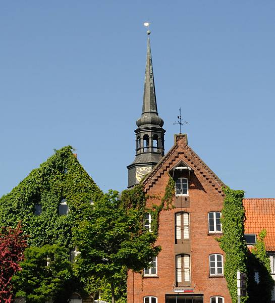 Speichergebäude Fassade Efeu bewachsen - St. Cosmae-Kirche. Tourismus in der Metropolregion Hamburg / Hansestadt Stade. 080_8074 Backstein-Speichergebäude am Ufer des Stader Hafens - unter dem Dach befindet sich ein Winde, mit der die Ware auf die einzelnen Speicherböden transportiert werden kann. Die Fassaden der Gebäude sind mit Efeu bewachsen. Dahinter der Barockturm der St. Cosmae Kirche.