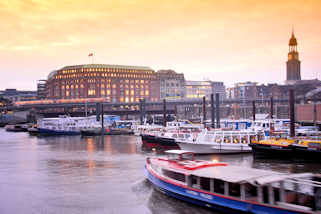 0054 Blick ber den Hamburger Binnenhafen zum Hochbahnviadukt am Steinhft - rechts der Kirchturm der Hamburger St. Michaeliskirche. Barkassen und Arbeitsboote liegen im Hafenbecken - eine Barkasse mit Touristen kommt aus dem Zollkanal und fhrt Richtung Elbe.