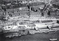 1277_016_47 Historische Luftaufnahme von den St. Pauli Landungsbrcken. Schlepper liegen an den Pontons - Schuten sind am Kai fest gemacht. In der Bildmitte das Tropeninstitut, lks dahinter das Hafenkrankenhaus. Rechts die Navigationsschule. Auf der linken Bildseite Etagenhuser in der Hafenstrasse mit Geschften in der Paterre.