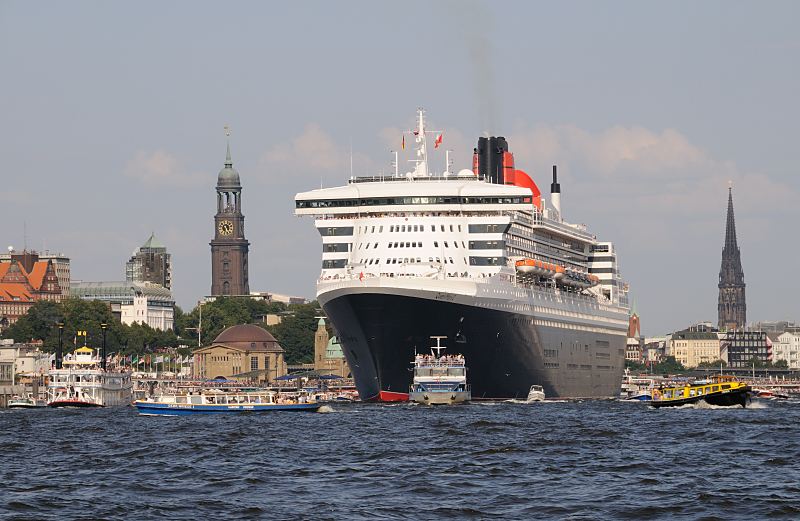 Das Passagierschiff Queen Mary 2 luft aus - Hamburg Panorama mit Michel und Nikolaikirche  06_4379 Die Queen Mary 2 verlsst den Hamburger Hafen; Im Hintergrund das Panorama von Hamburg mit der Kuppel vom Eingang des St. Pauli Elbtunnels. Dahinter der hohe Kirchturm des Hamburger Wahrzeichens, die St. Michaelis Kirche. Am Heck des Passagierschiff der kleine Turm der Gustav-Adolf-Kirche und rechts der Turm der St. Nikolaikirche, der als Kriegsruine zum Mahnmal fr die Opfer von Krieg und Gewalt in den Jahren 1939 - 1945 wurde www.fotograf- hamburg.de