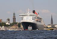 06_4379 Die Queen Mary 2 verlsst den Hamburger Hafen; Im Hintergrund das Panorama von Hamburg mit der Kuppel vom Eingang des St. Pauli Elbtunnels. Dahinter der hohe Kirchturm des Hamburger Wahrzeichens, die St. Michaelis Kirche. Am Heck des Passagierschiff der kleine Turm der Gustav-Adolf-Kirche und rechts der Turm der St. Nikolaikirche, der als Kriegsruine zum Mahnmal fr die Opfer von Krieg und Gewalt in den Jahren 1939 - 1945 wurde www.fotograf- hamburg.de