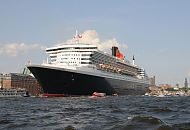 08_4390 Die Queen Mary 2 auf der Elbe vor Hamburg Altona, im Hintergrund der hohe Kirchturm des Hamburger Wahrzeichens, die St. Michaeliskirche. Die R.M.S. (Royal Mail Ship)  Queen Mary 2 (QM2) ist mit 148.528 BRZ eines der grten Passagierschiff der Welt. Das britische Kreuzfahrtschiff  hat eine Lnge von 345 m und eine Breite von 45 m. Der Luxusliner bietet in 1310 Kabinen bis zu 2.620 Passagieren Platz und hat eine Besatzung von 1.253 Personen. Die Queen Mary 2 hat fnf Swimmingpools, einen Ballsaal, Golfanlage, Wintergarten, Sportzentrum, mit ber 8.000 Bchern die grte Bibliothek auf See, den grten ffentlichen Saal (Restaurant Britannia), der ber zwei Decks und die gesamte Schiffsbreite geht, acht weitere Restaurants, Fitness-Center, Planetarium, Kino, Theater.  www.fotograf- hamburg.de