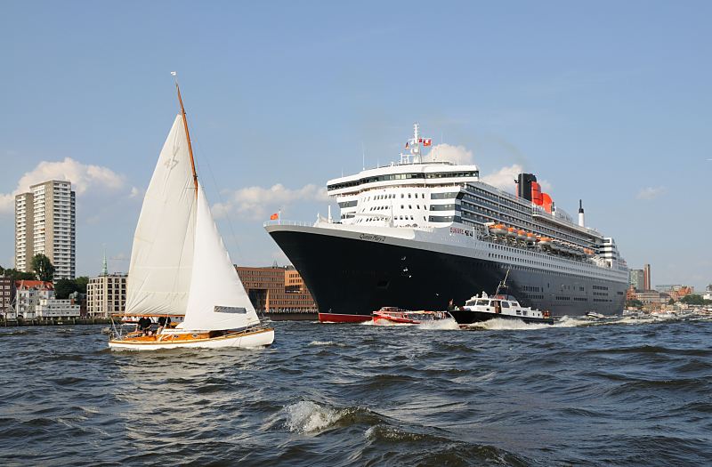 Die Queen Mary 2 auf der Elbe vor Hamburg Neumhlen; Motorboote, Barkassen, Segelschiff. 09_4393 Die Queen Mary 2 auf der Elbe vor Hamburg Neumhlen, viele Schiffe begleiten das riesige Passagierschiff; eine Segelyacht kreuzt vor dem Bug des Kreuzfahrtschiffs. Die R.M.S.(Royal Mail Ship)  Queen Mary 2 (QM2) ist mit 148.528 BRZ eines der grten Passagierschiff der Welt. Das britische Kreuzfahrtschiff  hat eine Lnge von 345 m und eine Breite von 45 m. Der Luxuslinerbietet in 1310 Kabinenbis zu 2.620 Passagieren Platz und hat eine Besatzung von 1.253 Personen. Die Queen Mary 2 hat fnf Swimmingpools, einen Ballsaal, Golfanlage, Wintergarten, Sportzentrum, mit ber 8.000 Bchern die grte Bibliothek auf See, den grten ffentlichen Saal (Restaurant Britannia), der ber zwei Decks und die gesamte Schiffsbreite geht, acht weitere Restaurants, Fitness-Center, Planetarium, Kino, Theater.  www.fotograf- hamburg.de