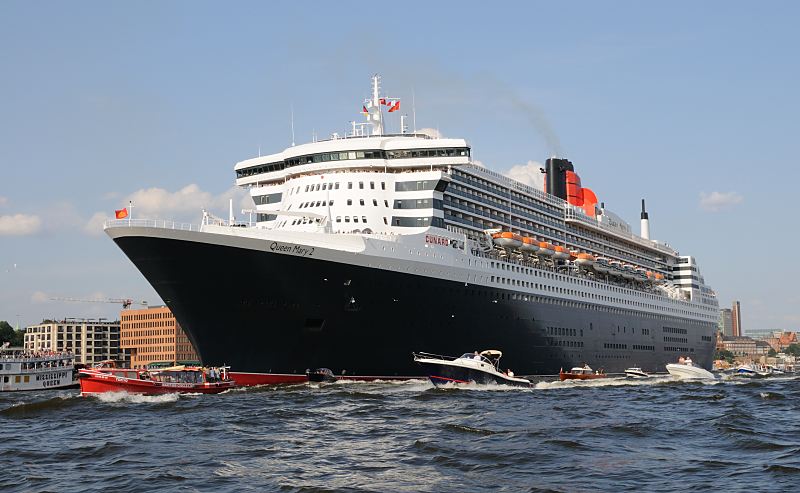 Die Queen Mary 2 auf der Elbe vor Hamburg Neumhlen; Motoryachten, Barkassen.10_4393 Die Queen Mary 2 auf der Elbe vor Hamburg Neumhlen, Motoryachten, Barkassen und Fahrgastschiffe der Hamburger Hafenrundfahrt verabschieden das Kreuzfahrtschiff. Die R.M.S. (Royal Mail Ship)  Queen Mary 2 (QM2) ist mit 148.528 BRZ eines der grten Passagierschiff der Welt. Das britische Kreuzfahrtschiff  hat eine Lnge von 345 m und eine Breite von 45 m. Der Luxusliner bietet in 1310 Kabinen bis zu 2.620 Passagieren Platz und hat eine Besatzung von 1.253 Personen. Die Queen Mary 2 hat fnf Swimmingpools, einen Ballsaal, Golfanlage, Wintergarten, Sportzentrum, mit ber 8.000 Bchern die grte Bibliothek auf See, den grten ffentlichen Saal (Restaurant Britannia), der ber zwei Decks und die gesamte Schiffsbreite geht, acht weitere Restaurants, Fitness-Center, Planetarium, Kino, Theater.  www.fotograf- hamburg.de