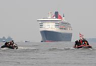 13_4638 Die Queen Mary 2 im Morgendunst vor Hamburg Finkenwerder. Zwei historische Festmacherboote aus dem Museumshafen Oevelgnne mit Schaulustigen Hamburgern an Bord fahren ihr entgegen, um das riesige Passagierschiff in Hamburg zu begrssen. www.fotograf-hamburg.de