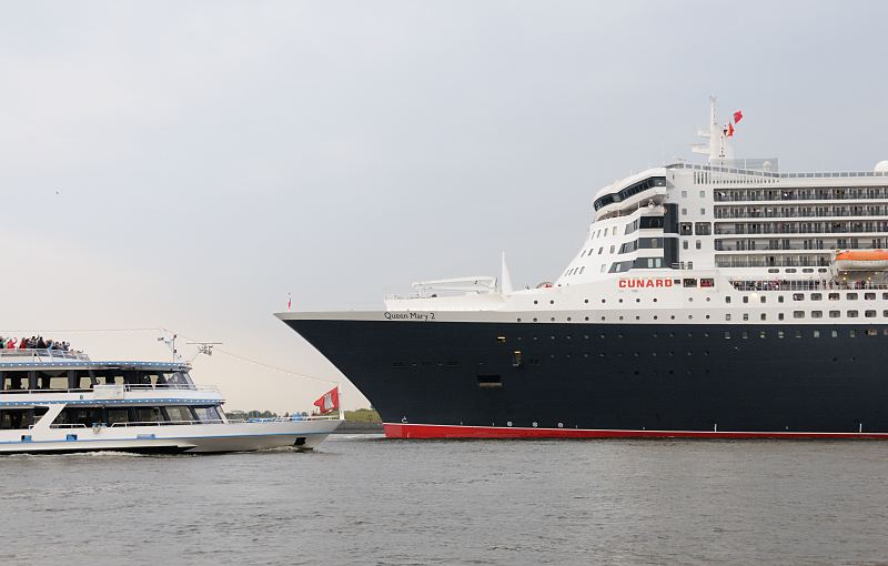 Hamburger Hafenbilder. Die Queen Mary 2 luft in Hamburg ein - ein Fahrgastschiff begrsst das Passagierschiff. Hamburger Hafenfotos -  Fotograf Christoph U. Bellin. 15_4650 Ein Fahrgastschiff der Hamburger Hafenrundfahrt ist der Queen Mary 2 auf der Elbe entgegen gefahren; die Passagiere an Bord begrssen das grosse Kreuzfahrtschiff in der Hansestadt Hamburg. Die Queen Mary 2 ist mit einer Lnge von 345 m und eine Breite von 45 m eines der grssten Passierschiffe der Welt. Der Luxuslinerbietet in 1310 Kabinenbis zu 2.620 Passagieren Platz und hat eine Besatzung von 1.253 Personen. www.fotograf-hamburg.de